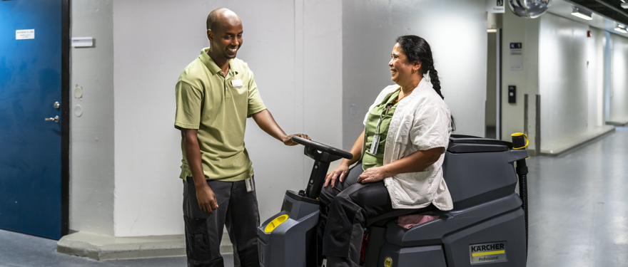 Servicearbetare möts i en sjukhuskorridor.