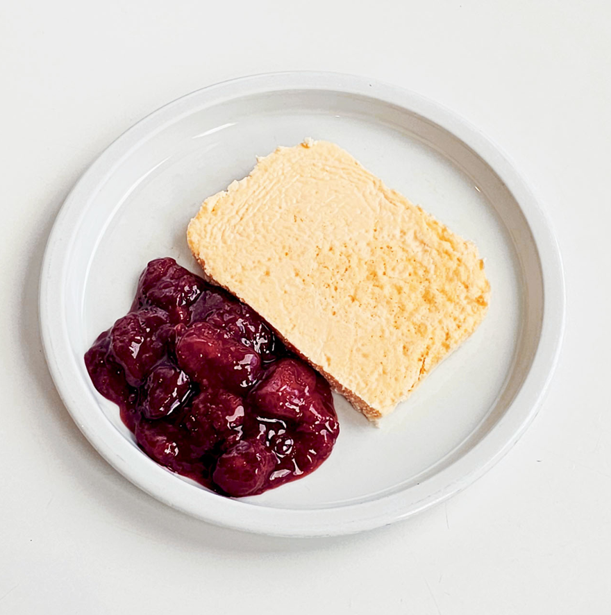 ostkaka med bärkompott på tallrik