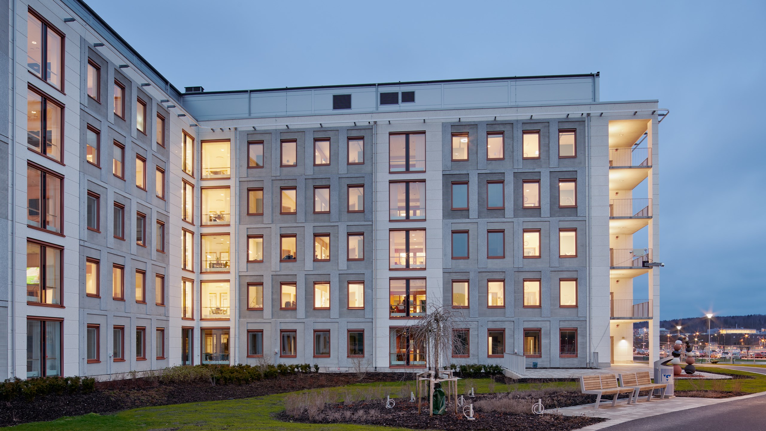 Exteriör på den södra delen av Kungälvs sjukhus nya vårdbyggnad, i skymning.