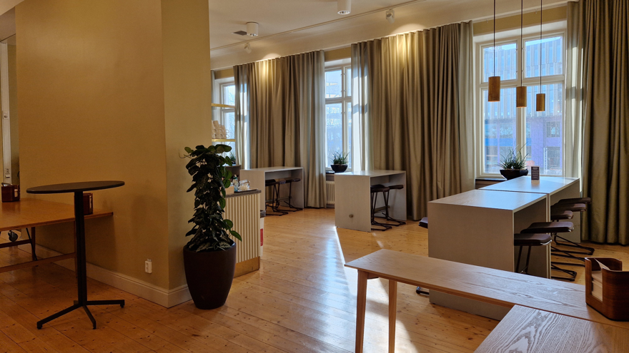 Fikayta med serveringsbord och lite högre matbord med tillhörande pallar samt ståbord.