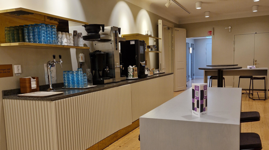 Fikayta mend kaffestation och högre matbord med tillhörande pallar samt några ståbord.